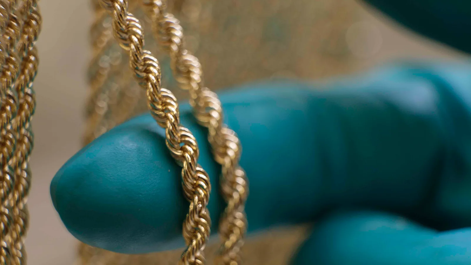 Gloved hand inspecting finished Mioro gold chains
